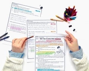 Woman holding color coded 2nd and 3rd grade reading passages