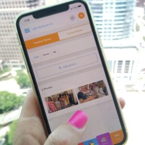 Image of a woman's hand holding a cell phone with the ClassTag App open to the Parent-Teacher communication page