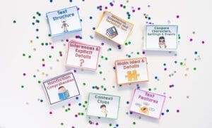 Task cards for practicing different reading comprehension skills and close testing gaps for standardized testing spread across a white surface with glitter background.