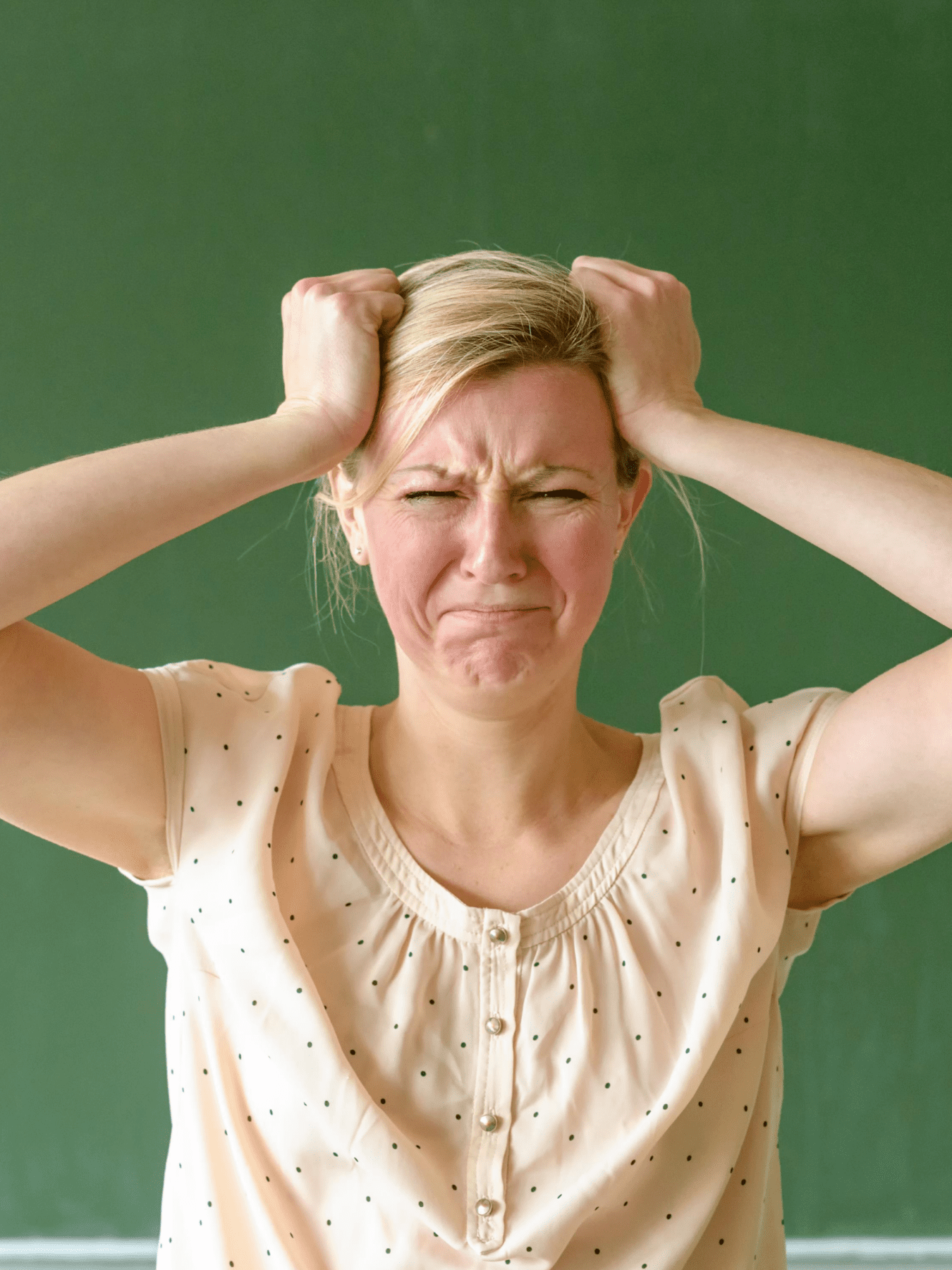 Frustrated teacher with chalkboard behind her