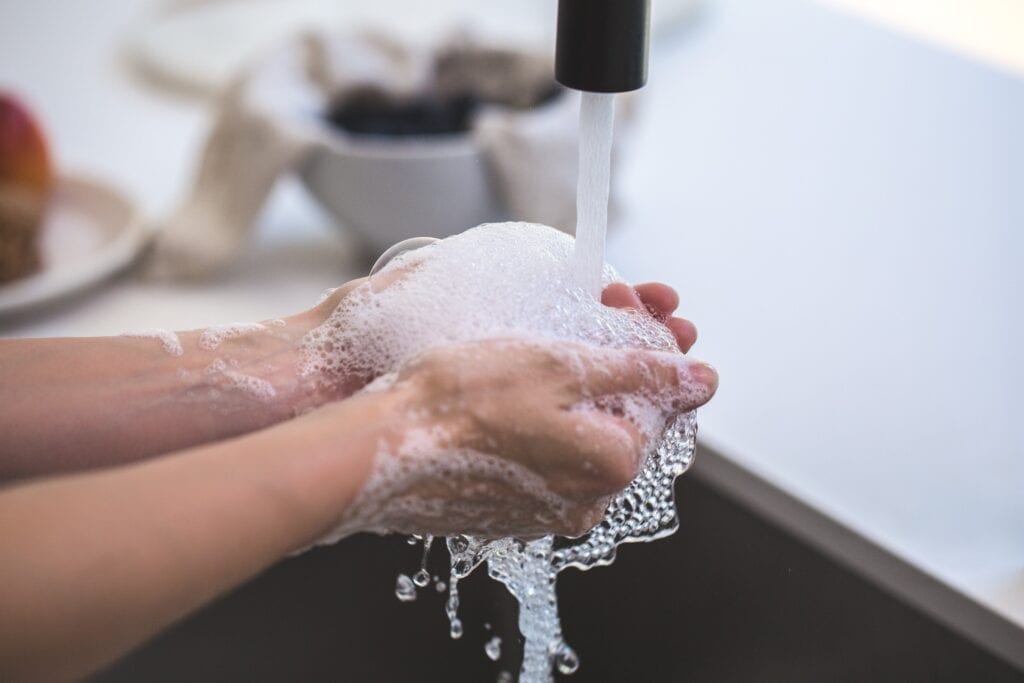 Kid washing hands to prevent the spread of COVID-19 in the classroom