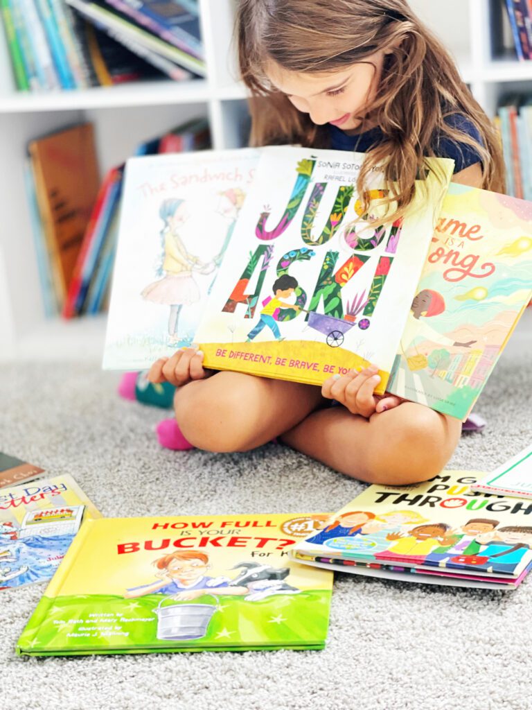 student holding books for back to school read aloud time