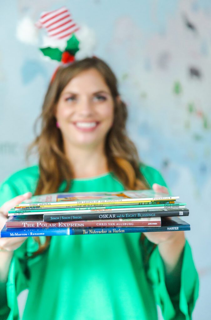 Teacher holding read aloud books about holidays in different cultures around the world