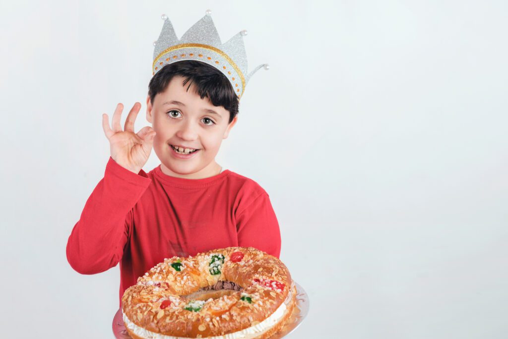 child with King cake or Rosca de Reyes, a Spanish dessert for Christmas